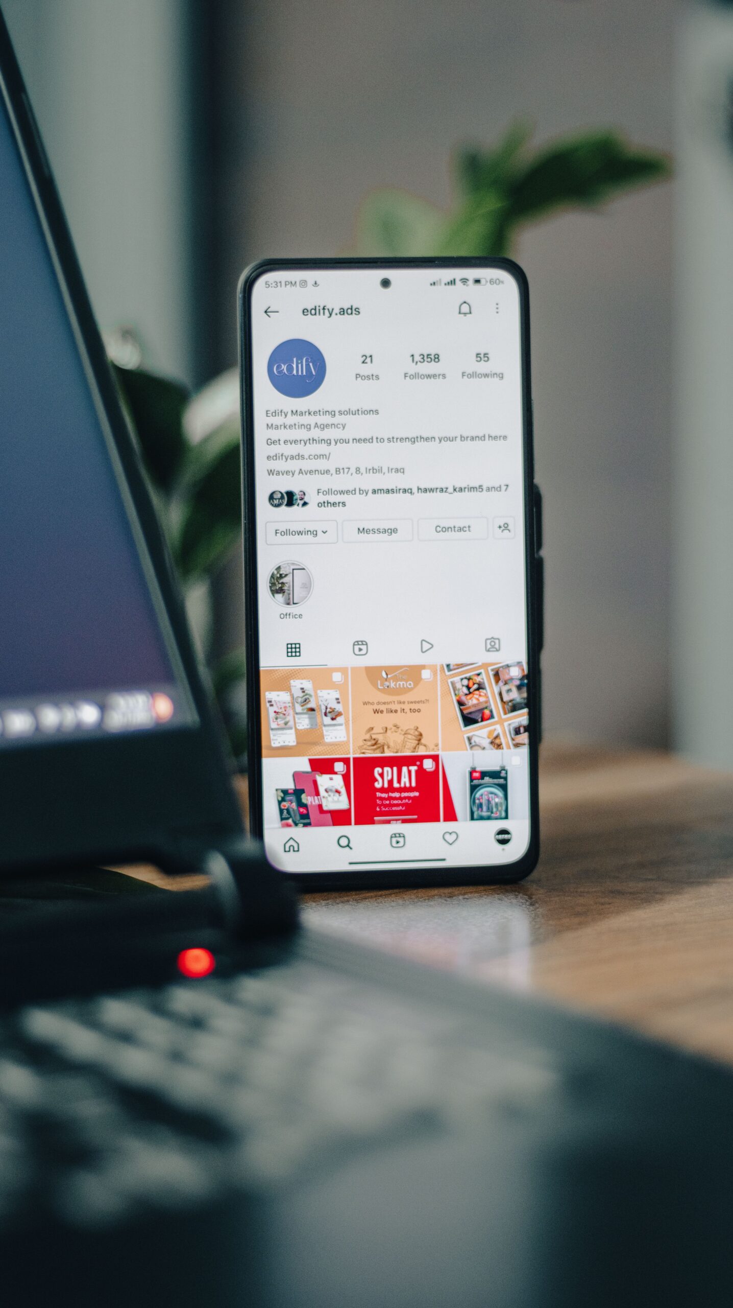 Smartphone with Instagram open beside a laptop for ad creative work